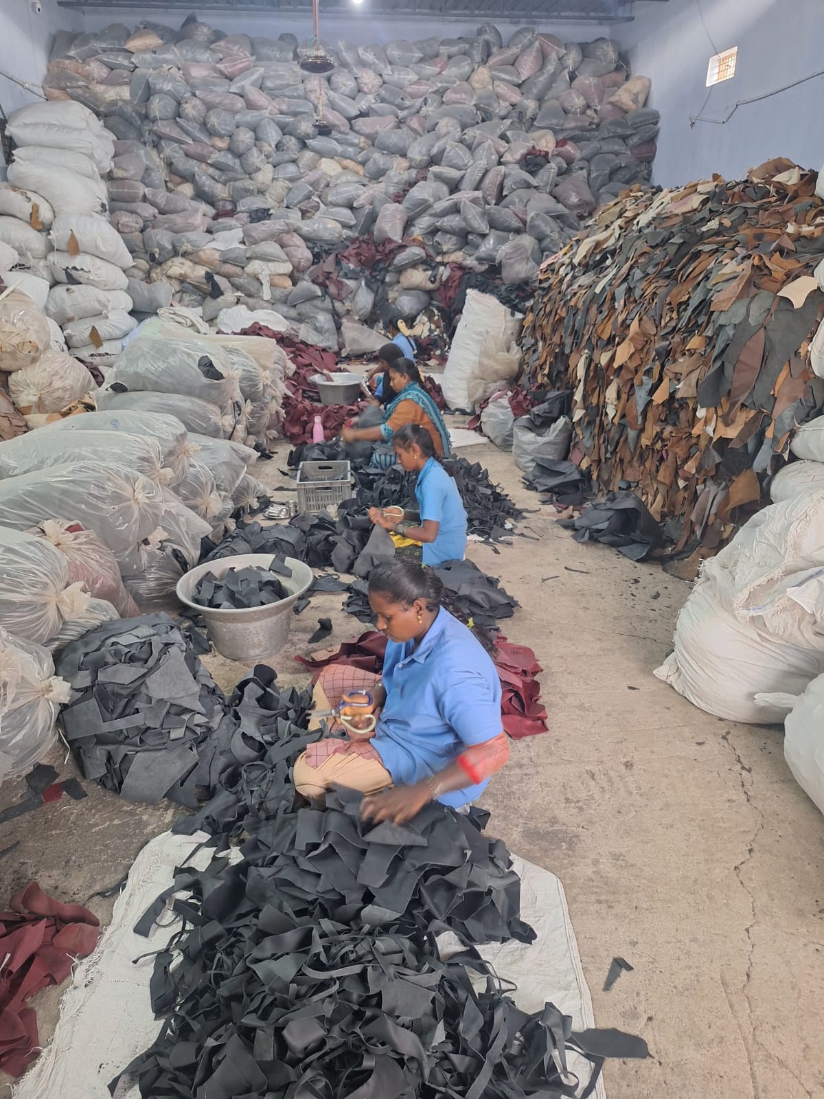 Large warehouse grading floor with workers and bags
